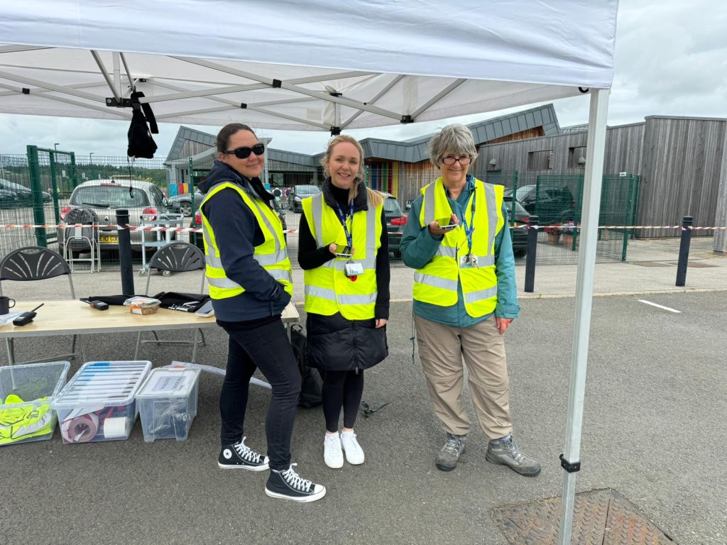 Volunteers under a marquee smiling.