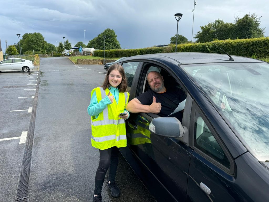 Child volunteer and customer posing for camera with thumbs up.